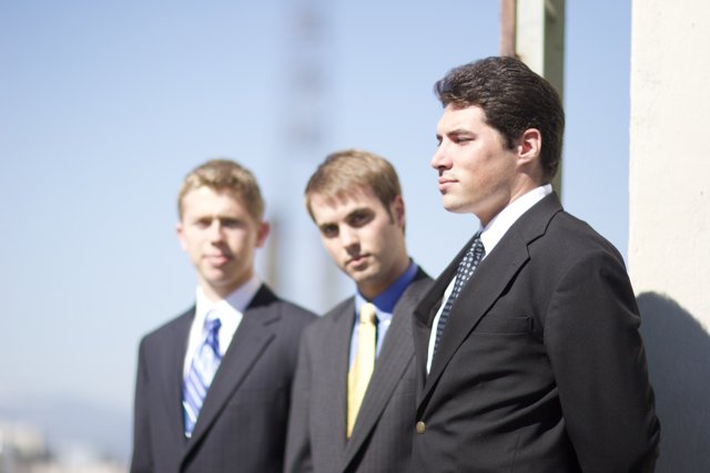 Three Men in Suits with Blue Sky Background