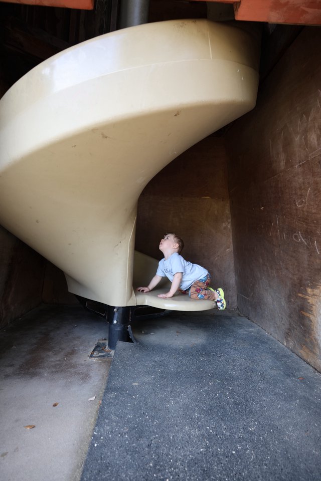 Young Child Climbing Curved Playground Slide at Fantasyland