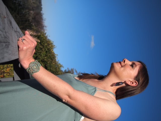 Sunlit Serenity: Woman in Turquoise Jewelry Against Sky