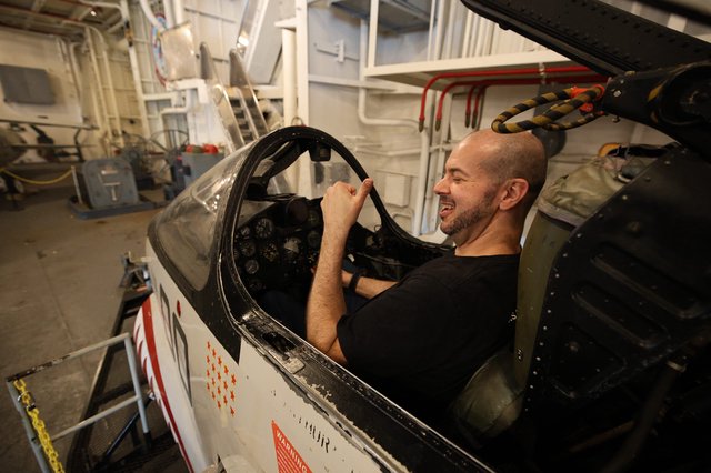 Visitor Enjoying Vintage Aircraft Cockpit at USS Hornet Museum