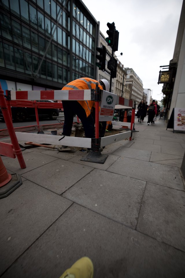 Construction Worker Maintaining Urban Sidewalk in London