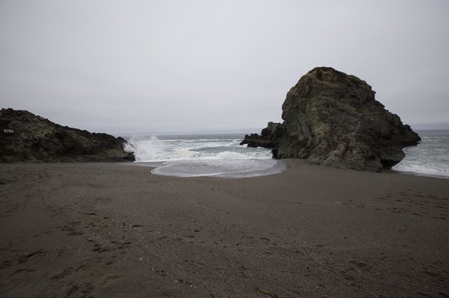 Moody Coastal Cove with Crashing Waves and Sea Stacks