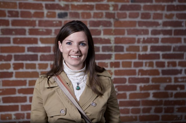 Smiling Woman Portrait Against Rustic Brick Wall