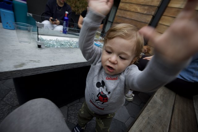 Toddler in Mickey Mouse Shirt Reaching Up