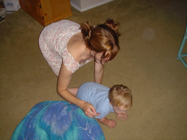 Mother Tenderly Cares for Toddler on Carpet Floor