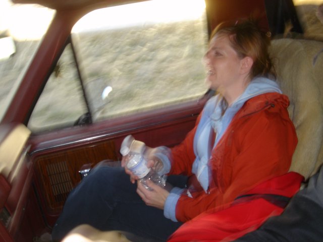 Woman Riding in Classic Car Through Desert Terrain