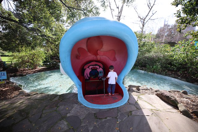Child Exploring Giant Mouth Sculpture at Fantasyland