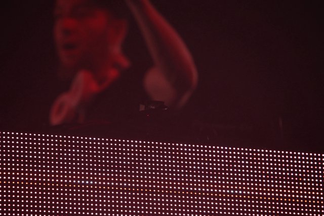 DJ Bathed in Red Light Above LED Stage