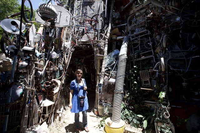 Woman Poses at Austin's Cathedral of Junk Entrance