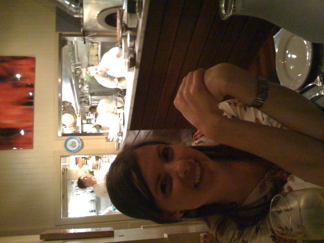 Woman Smiling at Open Kitchen Restaurant Table