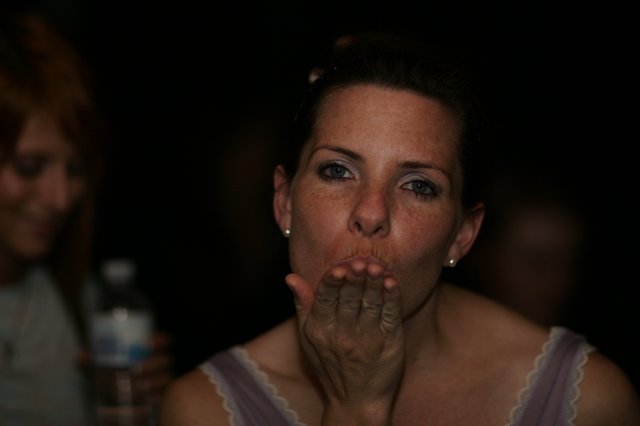 Woman Blowing a Kiss in Dim Party Light