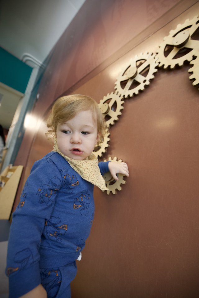 Curious Toddler Explores Interactive Gear Wall Display