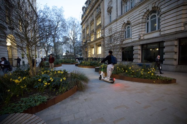 Electric Scooter Rider in London Garden Square at Dusk