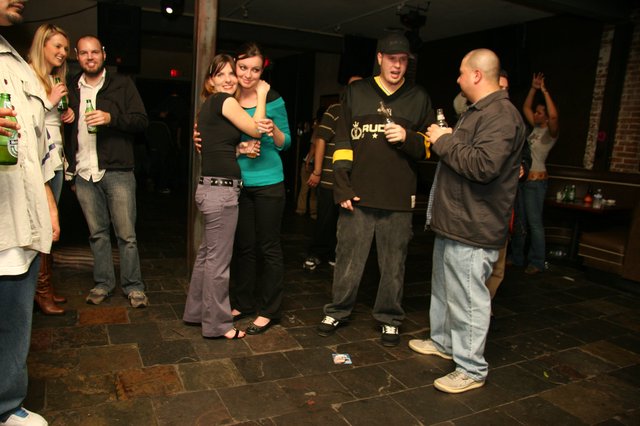 Friends Embrace at a Lively Holiday Bar Gathering