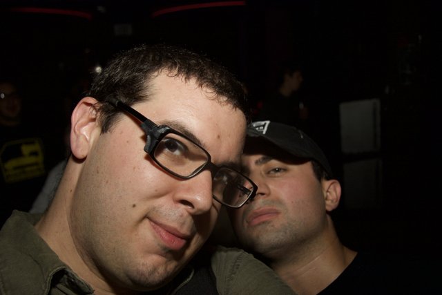 Two Glasses-Wearing Men Taking a Selfie at a Party