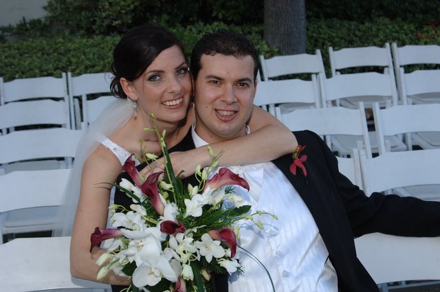 Newlyweds Embrace Amid White Wedding Chairs