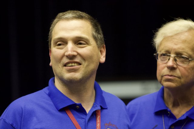 Two Grinning Men in Blue Shirts