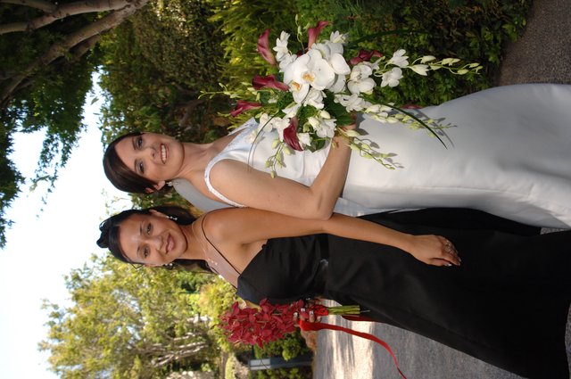 Bride and Bridesmaid Pose Back-to-Back in Garden