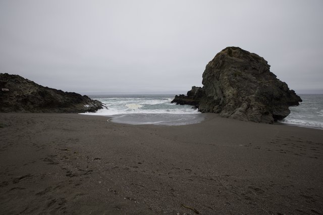 Rugged Cove Where Waves Meet Dark Sand
