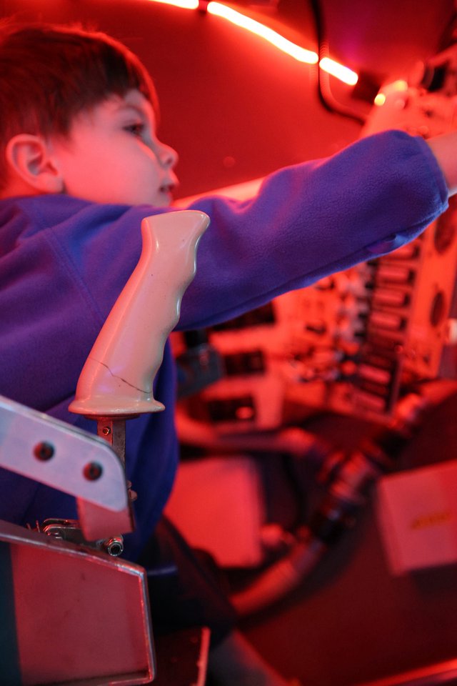 Child Interacting with Robotic Arm at Science Center