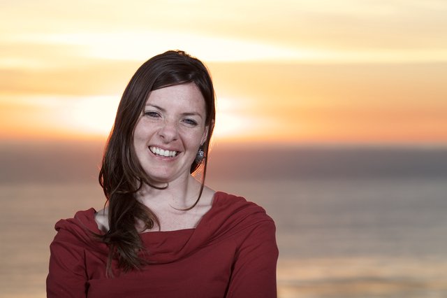 Radiant Woman Smiling at Sunset by the Sea
