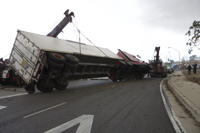 Overturned truck blocks path on busy road