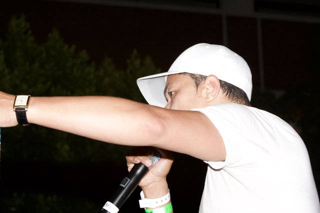 Man with a Microphone and a White Baseball Hat