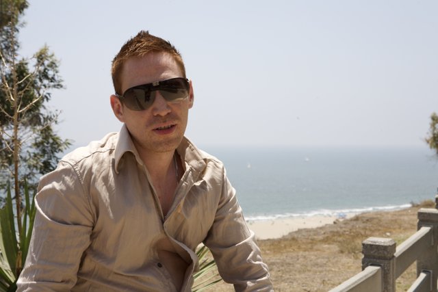 Man Smiling in Sunglasses by the Beach