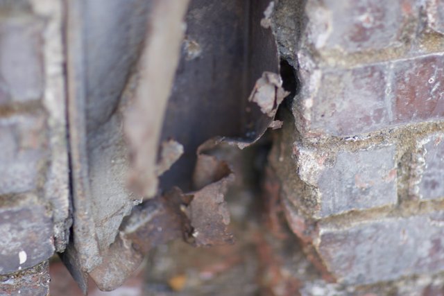 Rusty Metal Sticking Out of Brick Wall