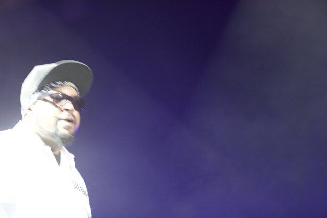 Man in Hat and Glasses Performing on Stage