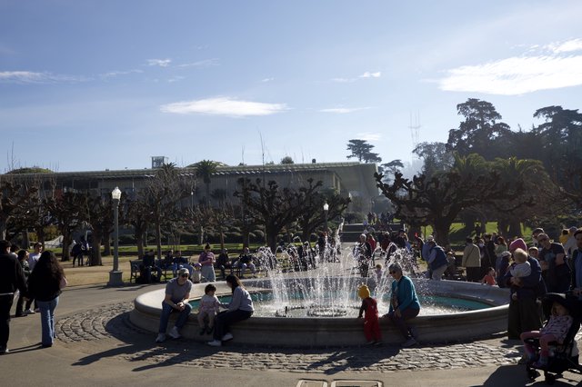 Families Gathering Around Fountain on Sunny Day