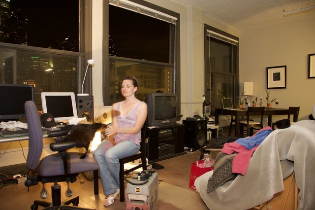 Young Woman Relaxing with Cat in City Apartment