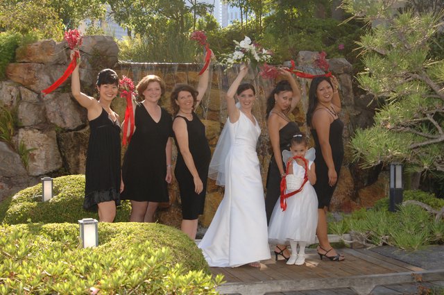 Bridal Party Celebrates with Bouquets at Garden Waterfall