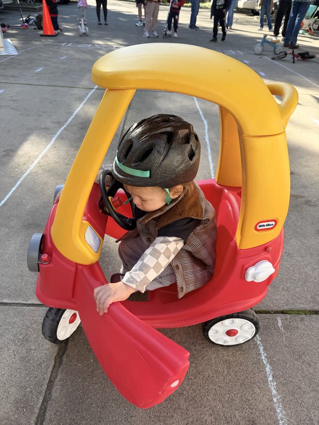 Young Child in Little Tikes Car at Community Event