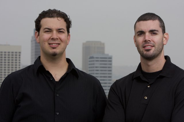 Two Happy Men in Black Shirts at a City Skyscraper