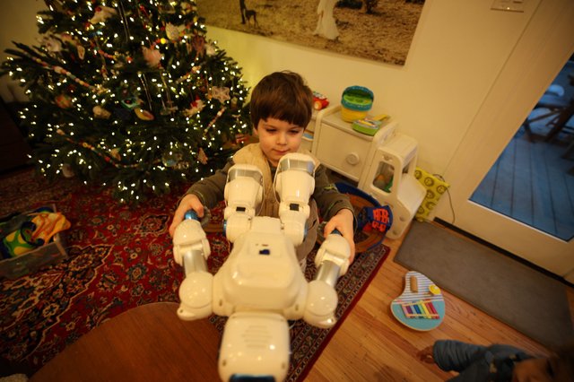 Child Playing with White Robot Toy on Christmas Morning