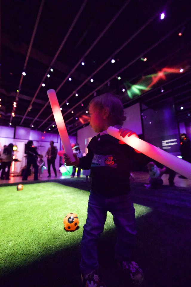 Child Playing with Light Sabers at Baby Rave Event