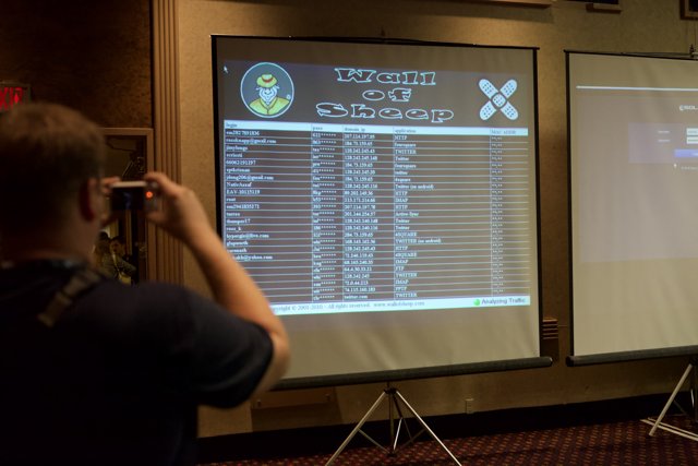 Man Capturing Projection Screen on Camera