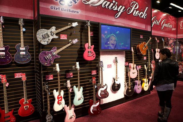 A Woman Admires the 22 Electric Guitars on Display