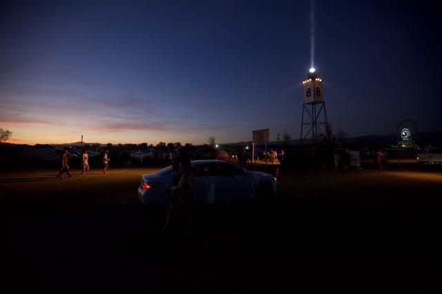 Parked Car by Light Tower at Dusk