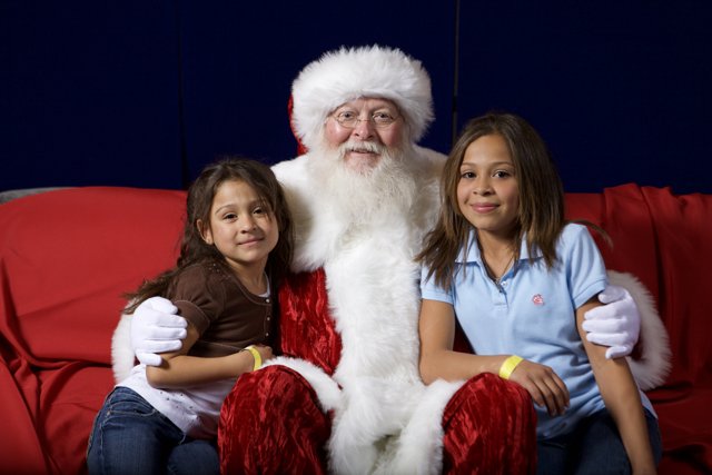 Santa Claus and Two Girls Sitting on a Couch