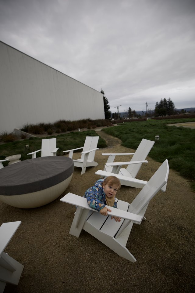 Toddler Playing Among Modern White Adirondack Chairs