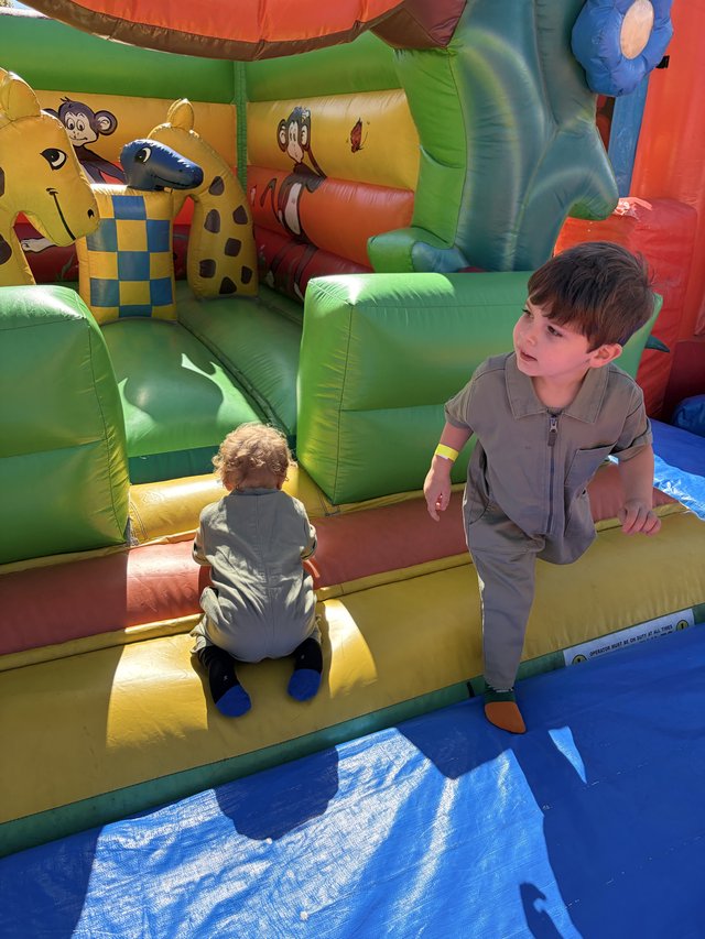 Two Boys Playing on Colorful Inflatable Bounce House
