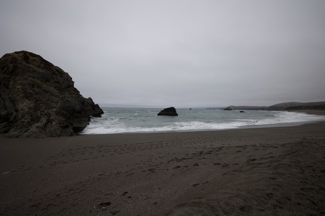 Moody Overcast Cove with Dark Volcanic Sand Beach