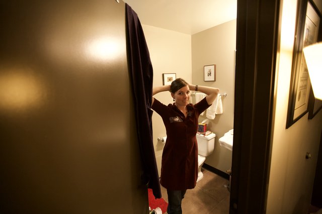 Woman Fixing Hair in Bathroom Doorway Portrait
