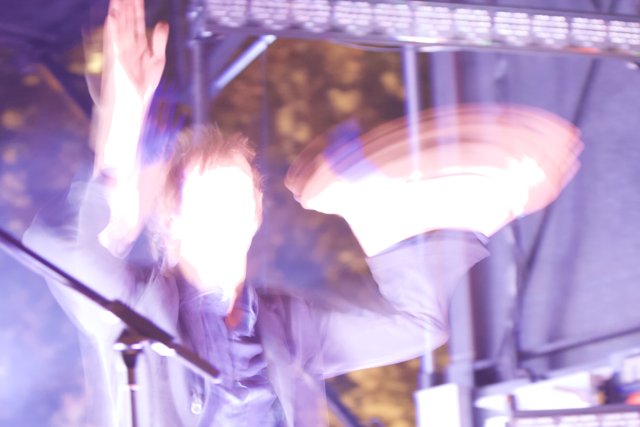 Blurred Man with Hands Up in Concert Crowd