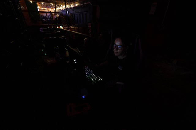 Lighting Technician Working in Darkened Concert Booth