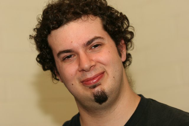 Curly-haired man smiling for the camera
