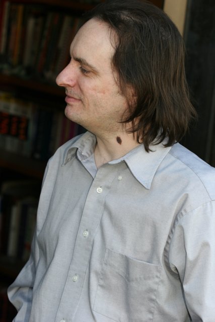Man with Long Hair Surrounded by Books