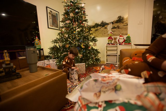 Child Unwrapping Presents on Christmas Morning 2025
